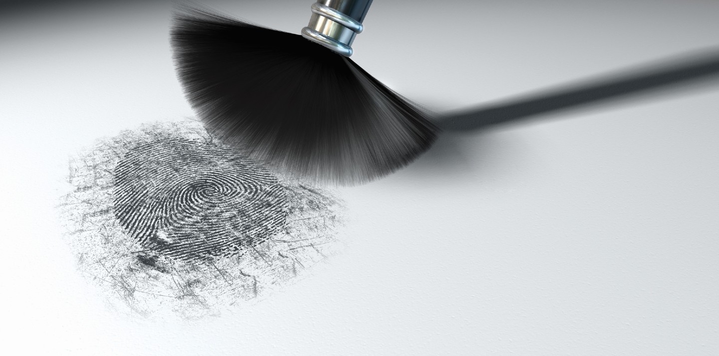 A crime scene brush dusting black talcum powder revealing a fingerprint mark on isolated white background.