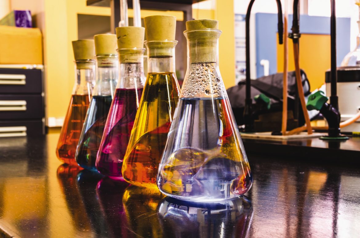 Flasks of colorful liquid sit on the lab bench