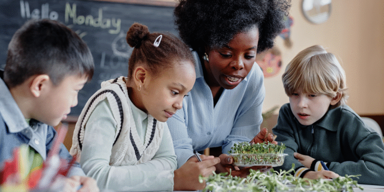 teacher showing students growing plants in classroom